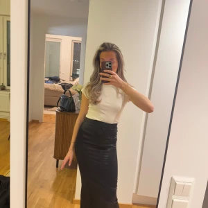 Svart lång satinkjol - Maxilång satinkjol i en tajtare modell, slits finns där bak, så man kan röra sig väldigt bra🥰.