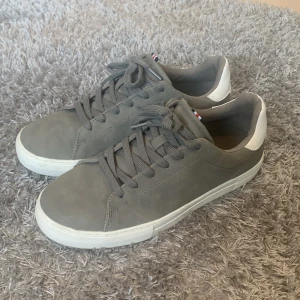 Grå sneakers från pier one - Snygga grå sneakers med vita detaljer och snörning. Skorna har en stilren design med en vit sula och en diskret logga på hälen. Perfekta för en avslappnad stil. Användt cirka 2-3 ggr