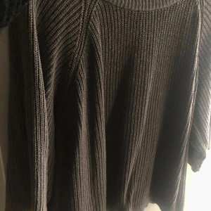 Grå stickad tröja - Säljer en mysig grå stickad tröja med rund hals och långa ärmar. Perfekt för kyliga dagar och enkel att matcha med olika outfits. Ett måste i garderoben för den som älskar komfort och stil.