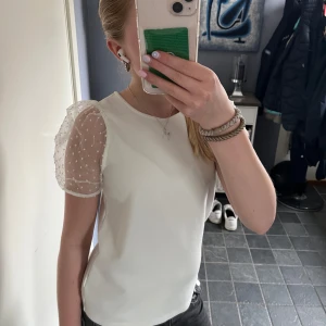 Vit topp med puffärmar - Vit topp med puffärmar som endast är använd en gång. Storlek 146-152 men skulle säga att det mer är XS-S. Tveka inte att skriva om ni har någon fråga!