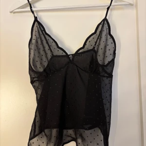 Svart prickig linnetopp från Zara - Säljer en svart, transparent linnetopp från Zara med små prickar. Toppen har tunna axelband och en luftig passform, perfekt för varma dagar eller som ett lager under en kavaj. Aldrig använd 
