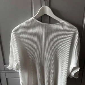 Vit ribbad topp - Snygg vit ribbad topp med tre kvarts ärmar. Materialet ger en skön och luftig känsla. Passar som S. Tröjan har några fläckar som säkert går bort i tvätten