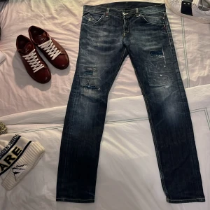 Dondup Jeans  - Snygga mörkblå jeans från Dondup med snygga slitningar. Jeansen har en knappstängning fram samt detaljerade bakfickor. Dem är i bra skick med en liten skada som är lagad, men smälter in i designen så det är inget man uppmärksammar. Modellen är ca. 185 cm och dem passar perfekt i längden. Ligger på ungefär 3000 kr nya. Har du fler frågor så svarar jag gärna. Jag tar gärna emot byten också.