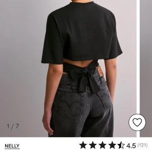 Svart croppad topp från Nelly - Snygg svart croppad topp från Nelly med korta ärmar och knytning i ryggen. Perfekt för en trendig look.