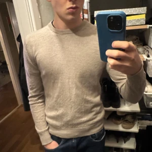 Beige ulltröja från Riley - Säljer en stilren beige tröja från Riley i mjuk merinoull. Inga fläckar eller hål, den är knappast använd jag på bilden är 186cm