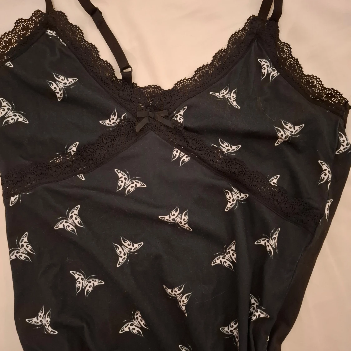 Svart body con klänning med fjärilsmönster