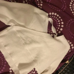 Vit ribbad omlottopp - Säljer en stilren vit ribbad omlottopp med lång ärm. Toppen är croppad och har en v-ringad design som ger en modern look. . Använt några gånger . Är väldigt varm och skön 