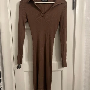 Brun ribbad klänning - Snygg brun ribbad klänning i storlek S. Klänningen har långa ärmar och en stilren krage. Perfekt för en chic och bekväm look. Aldrig använd!!❤️