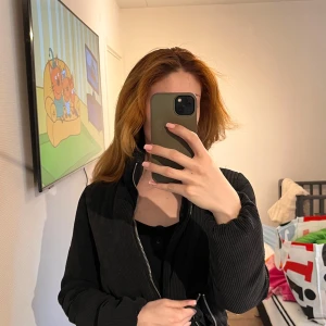 Svart manchesterjacka - Snygg svart manchesterjacka med dragkedja framtill. Jackan har en stilren design med långa ärmar och en normal passform. Perfekt för att ge en cool touch till din outfit.