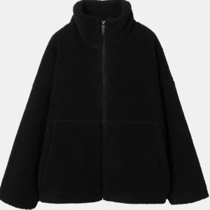 Svart teddyjacka med dragkedja - Mysig svart teddyjacka med dragkedja och hög krage. Perfekt för kyliga dagar med sin fluffiga och varma design. Jackan har långa ärmar och två stora fickor framtill. (Lånade bilder) skriv för fler bilder! 