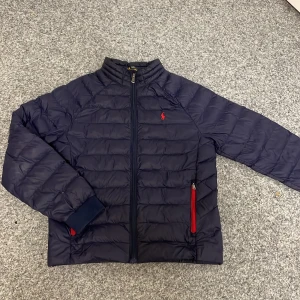 Blå pufferjacka från Ralph Lauren - Säljer en snygg blå pufferjacka från Ralph Lauren. Säljer den för att den inte passar mig längre. Inget som är trasigt på jackan eller något. Skriv vid minsta fundering/mvh Noel 