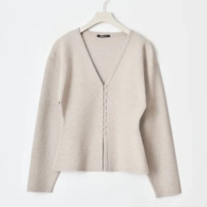 Gina kofta - Snygg beige kofta från Zara med v-ringning och knappar framtill. Perfekt för en stilren look. Långärmad och i ett mjukt material som ger en bekväm passform.