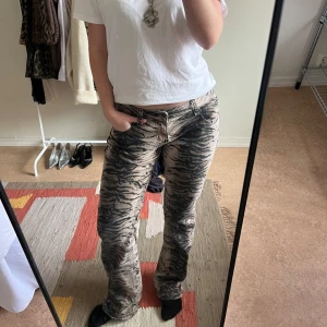 Zebramönstrade byxor - Snygga zebramönstrade byxor i beige och svart. De har en straight passform och är lågmidjade, vilket ger en trendig look. De är använda 2 gånger och väldigt bra skick!! Jag är 170 för preferens (nypris 1095kr)