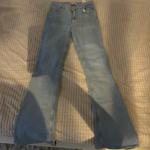 Ljusblå bootcut jeans - Snygga ljusblå bootcut jeans med hög midja. Perfekta för en avslappnad stil. Klassisk femficksdesign och dragkedja framtill.