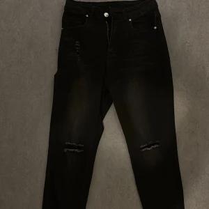 Svarta jeans från Shein - Snygga svarta jeans från Shein i storlek S. De har en tight passform med slitna detaljer vid knäna och fransade benslut. Perfekta för en trendig look. Använt 1 gång 