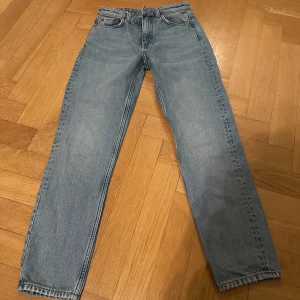Blå jeans från Weekday - Snygga blå jeans från Weekday i modellen Seattle och har en rak passform. Perfekta för en avslappnad stil. Storlek W 24 L 28, mid/low waist