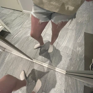 Ljusa jeansshorts med fransar - Säljer ett par ljusa jeansshorts med fransiga kanter och  4 knappar framtill, säljer då dom är för små och inte kommer till andvädning de är högmidjade. Köpta för 300kr. Pris kan diskuteras!!