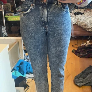 Acid wash jeans från H&M Divided - Säljer ett par coola acid wash jeans från H&M Divided. De är högmidjade med en klassisk femficksdesign och dragkedja. Perfekta för en avslappnad stil med en vintage touch.