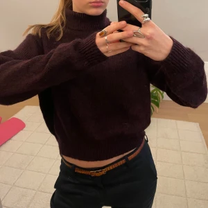 Vinröd stickad polotröja - Säljer en mysig mörklila/ vinröd stickad polotröja med långa ärmar. Tröjan användes nästan aldrig så är i toppskick! 