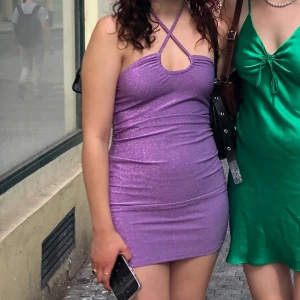 Lila glittrig klänning - Säljer en snygg lila glittrig klänning med halterneck-design. Klänningen är kort och tight, perfekt för en utekväll.💜