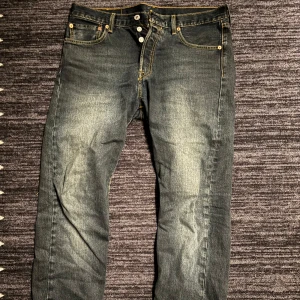 Levi's 501 jeans - Klassiska Levi's 501 jeans i en snygg blå tvätt. De har en knappgylf och femficksdesign med den ikoniska röda Levi's-lappen på bakfickan. Perfekta för en avslappnad stil. 