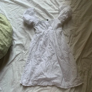 Vit klänning från H&M - Säljer en söt vit klänning från H&M i 100% återvunnen polyester. Klänningen har puffiga kortärmar och en smickrande passform. Perfekt för sommarens varma dagar. 🌼 xxs men passar xs också