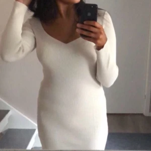 Beige ribbad klänning från Chiquelle - Säljer en stilren beige ribbad klänning från Chiquelle. Klänningen har en v-ringad hals och långa ärmar, perfekt för en elegant look. Perfekt för både vardag och speciella tillfällen.