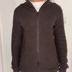 Brun stickad kofta från John Henric - Säljer en stilren brun stickad kofta från John Henric. Koftan har en dragkedja framtill och långa ärmar, perfekt för kyligare dagar. Den är i storlek M. Är knappt använd med inga defekter, är helt som ny. Köpt för 1299 på John Henric och säljer för 699kr