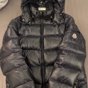 Moncler Maya - Säljer en snygg mörkblå Moncler Maya som är trendigt just nu! Den har en lite defekt som inte är synlig alls, ingen har kommenterat den eller sett den. Säljer den för jag är ute efter något annat. Perfekt för vintern och äkta såklart. För fler bilder eller frågor är det bara att skriva!