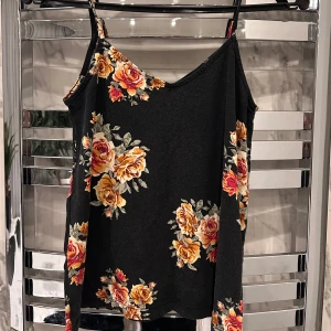 Blommigt linne  - Säljer ett svart linne med blommigt mönster i storlek S. Köparen står för frakten! 💗