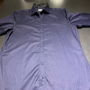 Mörkblå skjorta från Stenströms - Säljer en elegant mörkblå skjorta från Stenströms i 100% bomull. Skjortan har långa ärmar och knappar framtill. Perfekt för en stilren look. Storlek 41, vilket motsvarar en herr M.