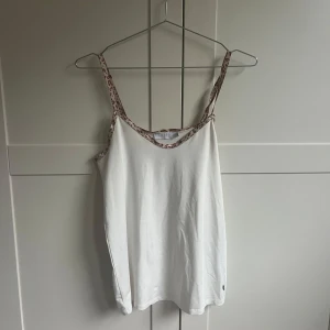 Vit linnetopp från Coster Copenhagen - Säljer en stilren vit linnetopp från Coster Copenhagen. Toppen har smala axelband med leopardmönster🌸Säljer för 100kr + frakt