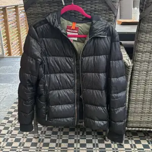 Säljer en snygg svart dunjacka från Parajumpers i okej skick. Jackan är är i storlek yl(Young large) men den sitter som en S i vuxen storlek. Det är 2  små hål  ermen och även bröstet men Inget man märker till. Vid fler frågor är de bara och skriva