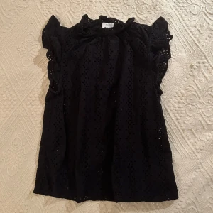 Svart topp från & Other Stories - Säljer en superfin svart topp från & Other Stories. Toppen är ärmlös med volangdetaljer vid axlarna. Perfekt för både vardag och fest🫶🏽