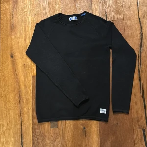 Svart tröja från Jack & Jones - Säljer en stilren svart tröja från Jack & Jones i storlek 164. Perfekt för både vardag och skola. Tröjan är i bra skick och har långa ärmar. Den är gjord i ett bekvämt material som passar bra till höst och vinter. Enkelt att matcha med jeans eller chinos!
