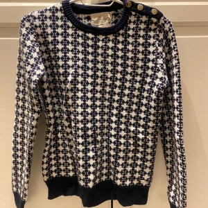Stickad tröja  - Säljer denna jättefina stickade tröjan från ”Holly & Whyte, den är vit med marinblåa detaljer och även guldfärgade knappar på ena axeln💕