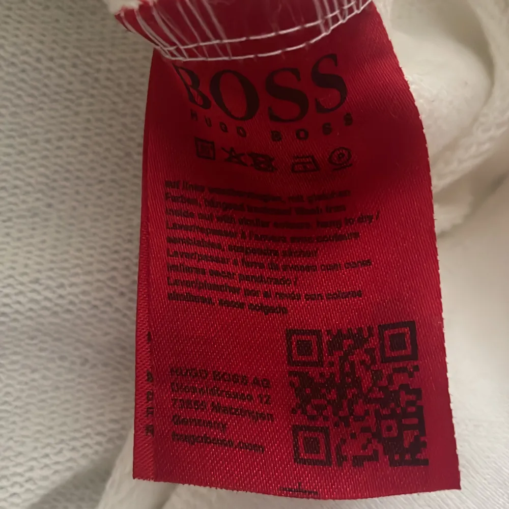 Säljer en stilren vit sweatshirt från Hugo Boss i storlek L. Tröjan har ett snyggt broderat BOSS-märke i guld på framsidan. Perfekt för en avslappnad men ändå trendig look. Passar bra till både jeans och joggers. 🕶️. Neuletakit & Villapaidat.