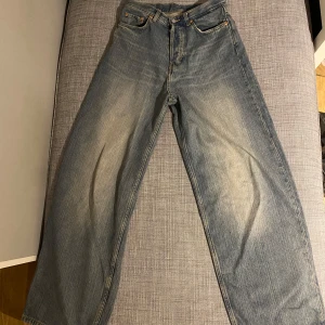 Weekday Astro Loose Baggy Jeans - Säljer ett par Weekday Astro Loose Baggy Jeans i blå denim. Använda 1 gång så dem är helt i nysskick. De har en avslappnad passform med breda ben och en klassisk femficksdesign. Perfekta för en casual look och superbekväma att bära. Passar både till vardags och chillhäng. Hör av dig vid intresse! 