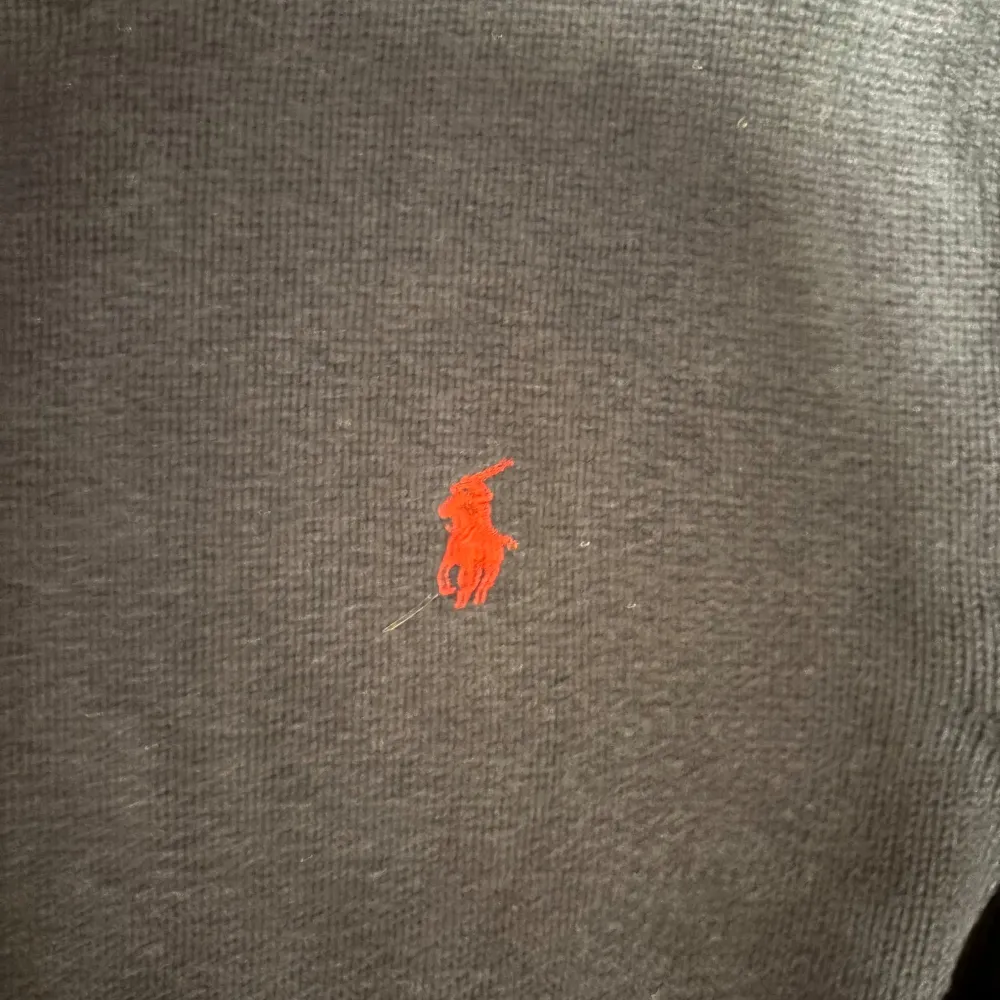 Säljer en snygg mörkblå tröja från Ralph Lauren med det klassiska röda logotypbroderiet på bröstet. Tröjan är i bra skick och har ribbade muddar vid ärmslut och nederkant. Perfekt för både höst och vinter!. Tröjor & Koftor.