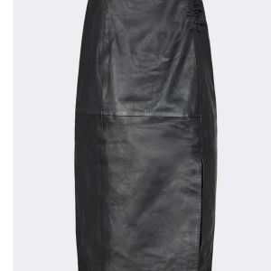 Svart skinnkjol från Levate - Snygg svart skinnkjol från Levate i storlek 36. Kjolen har en stilren design med en slits på sidan och dragkedja bak. Perfekt för både vardag och fest! 🖤