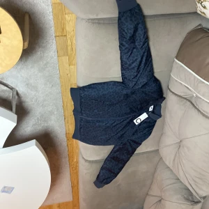 Jacka  - Säljer en snygg mörkblå bomberjacka med leopardmönster från märket C. Jackan har en dragkedja framtill och en ljusrosa insida som ger en cool kontrast. Perfekt för höst och vår! Jackan är i nytt skick med taggen kvar.