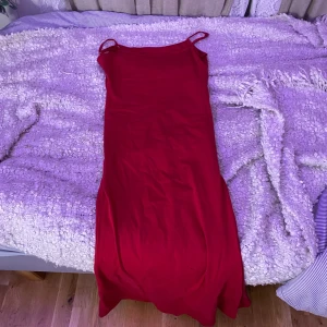Röd axelbandslös klänning - Säljer en snygg röd axelbandslös klänning i ett mjukt material. Perfekt för festliga tillfällen eller en utekväll. Klänningen har en tight passform och är i mycket bra skick. Passar perfekt för sommarens alla fester!