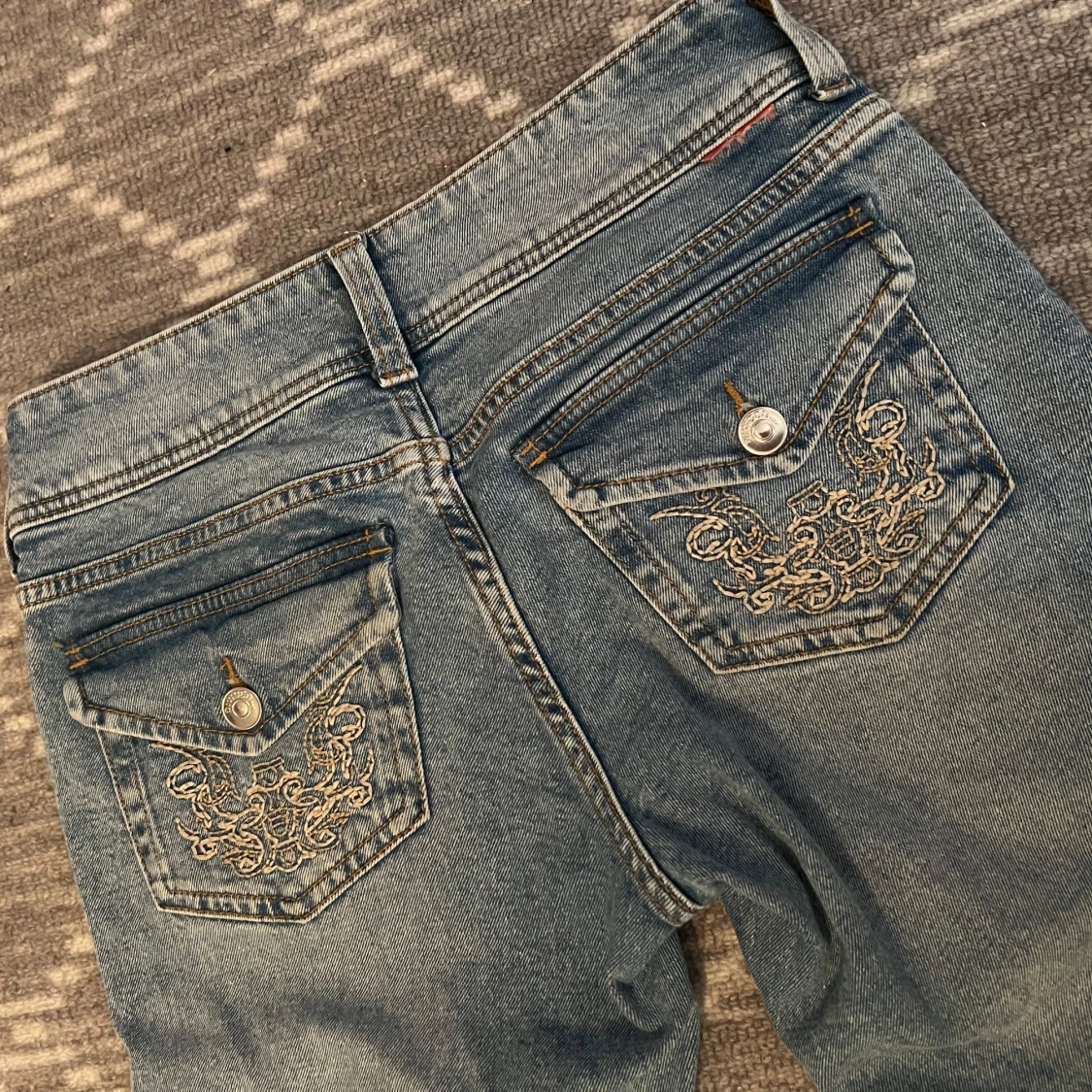 Blå bootcut jeans med broderade fickor