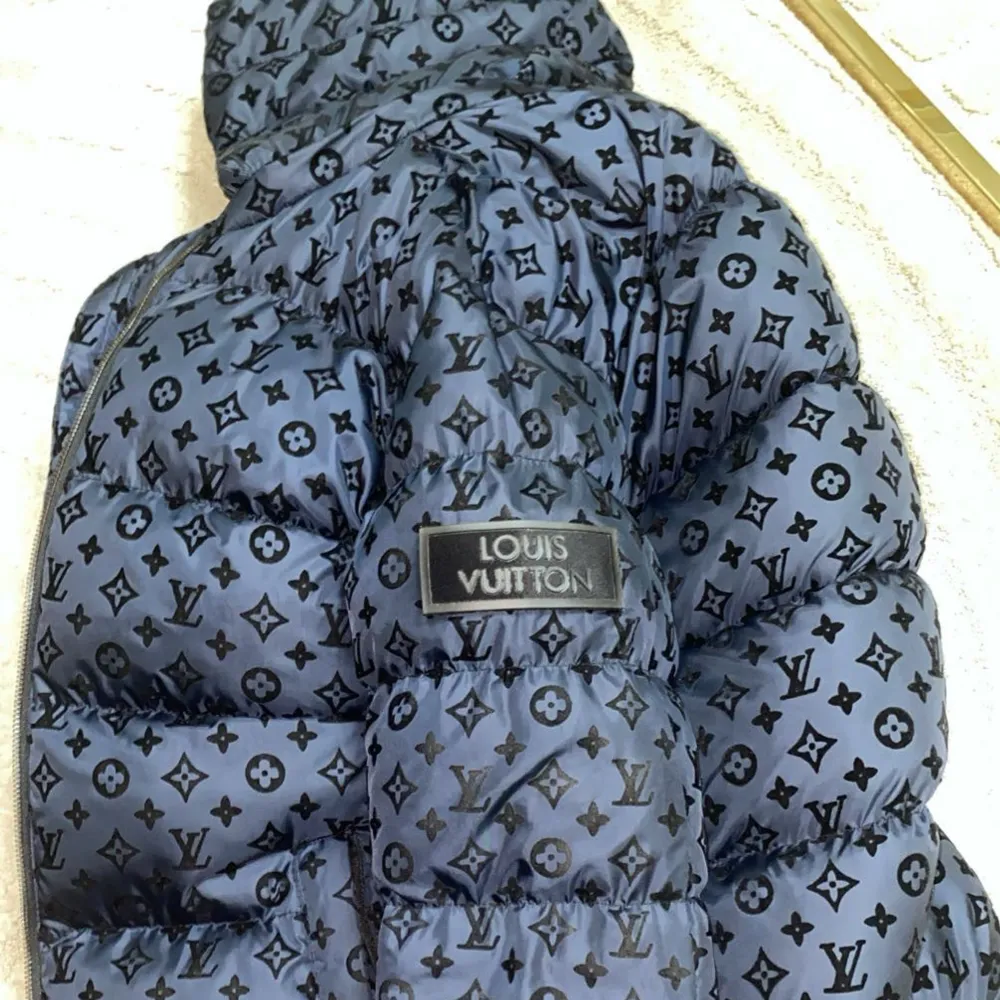 Säljer en snygg mörkblå pufferjacka från Louis Vuitton med deras ikoniska monogrammönster. Jackan har en dragkedja och en mysig huva, perfekt för kyliga dagar. Den är i mycket bra skick och passar perfekt för både höst och vinter.  Diskuteras vid snabbt affär.  Använd 3-4 gånger!. Jackor.