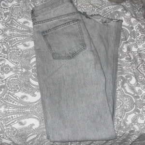 Grå jeans från Gina - Säljer ett par grå jeans från Gina i storlek 32. De har en klassisk femficksdesign och är i bra skick. Jeansen har en rak passform och är perfekta för vardagsbruk. De är bekväma och stilrena, vilket gör dem lätta att matcha med olika outfits.