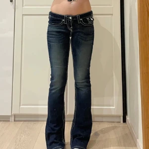 Mörkblå bootcut jeans - Säljer ett par snygga mörkblå true religion bootcut jeans i mycket bra skick. De har en låg midja och coola kontrastsömmar❤️köpte från plick och säljer vidare billigare då dom inte passade min stil❤️