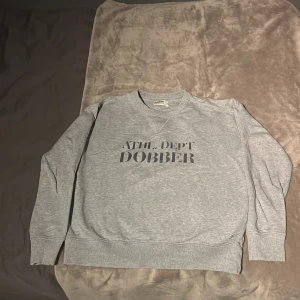 Grå sweatshirt från Dobber - Säljer en grå sweatshirt från Dobber i bra skick. Den har en normal passform och är perfekt för både höst och vår. Tröjan har ett tryck på framsidan. Storleken är large men passar medium också. Superbekväm och stilren!