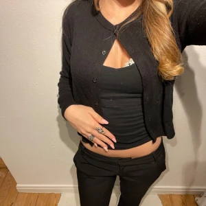 Svart kofta  - Säljer en svart kofta med knappar och ett matchande. Koftan är perfekt för lager-på-lager och har en klassisk stil. Koftan är i strl M men skulle säga mer xs/S då den är liten i storleken! 