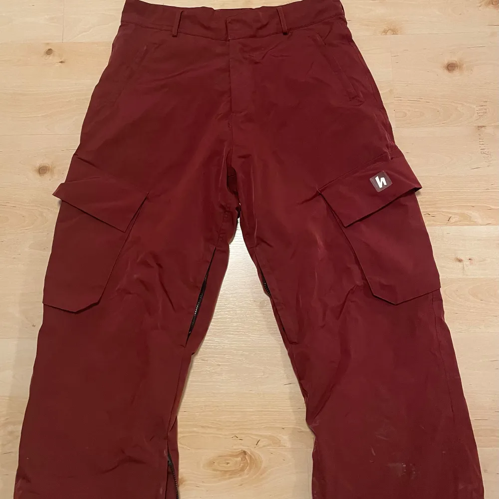 Harlaut cargo pants i färgen vinröd. Åkta på 2 säsonger, storlek M. skick efter bilder. Pris ej hugget i sten, skriv vid frågor. Nypris 1900kr.  . Jeans & Byxor.