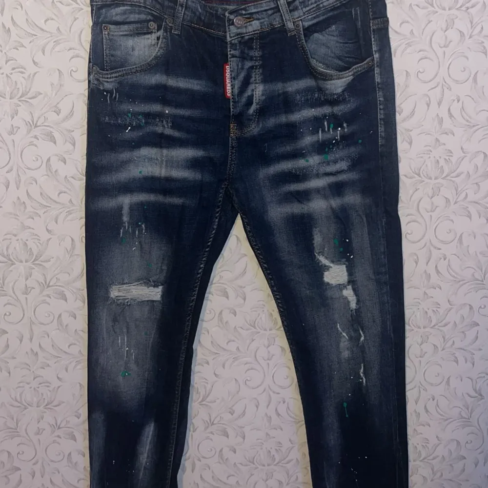 Säljer ett par snygga blå jeans från Dsquared2 i regular fit. (Storlek 52) De har en cool slitning och färgstänk som ger en unik look. Perfekta för både vardag och fest! Om du har mer frågor skriv privat ! MVH Viggo. Jeans & Byxor.